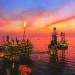oil rig in the middle of the sea at sunset